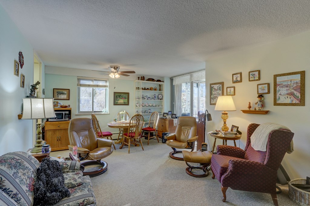 a living room filled with furniture and a dining room with chairs