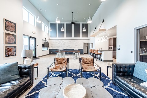 A modern living room with black leather couches and a white coffee table.