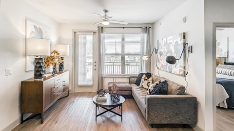 A living room with a couch, a coffee table, and a side table with a lamp.