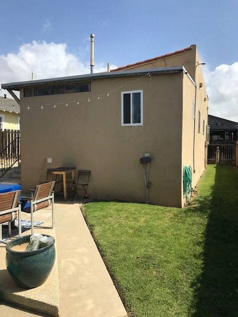 A tan house with a green pot in front.