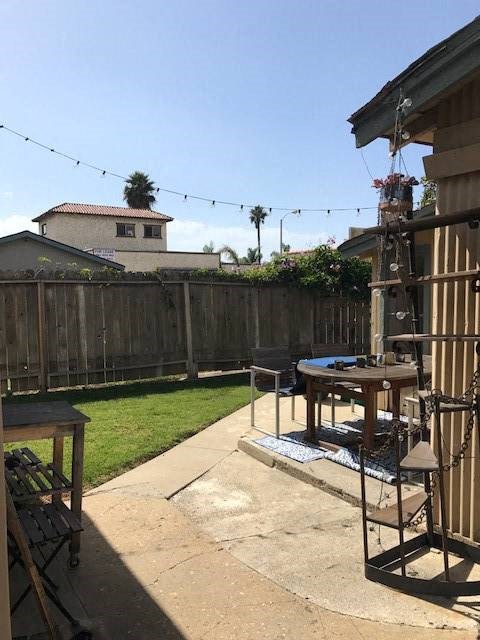 A backyard with a pool table and a fence.