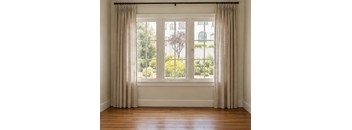 A room with a large window and curtains.