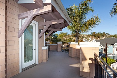 A balcony with a white door and a railing.
