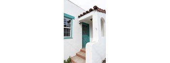 a white house with a green door and a window