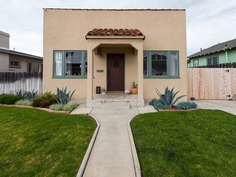 A house with a brown door and green window frames.