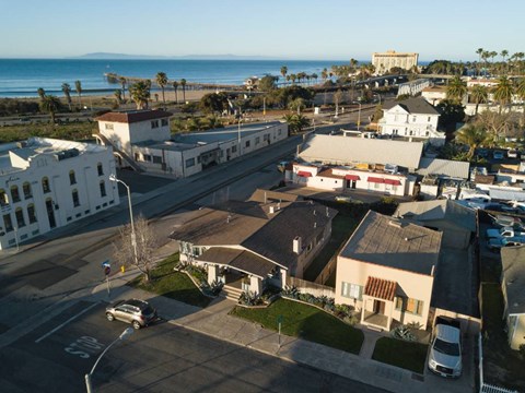 A coastal town with a view of the ocean and a large white building in the distance.