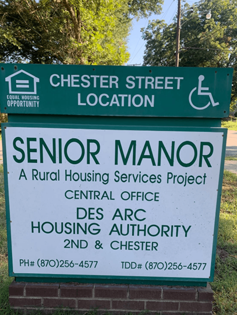 a sign for the senior manor housing services project on the side of the street