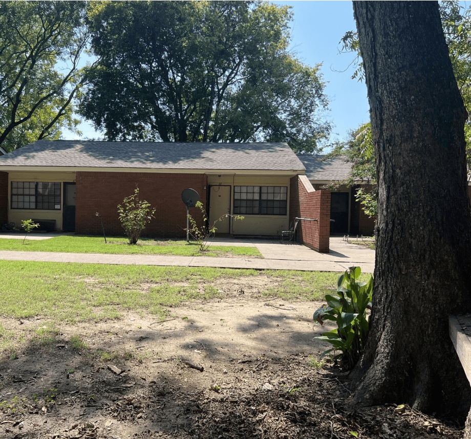 a house with a yard and a tree in front of it
