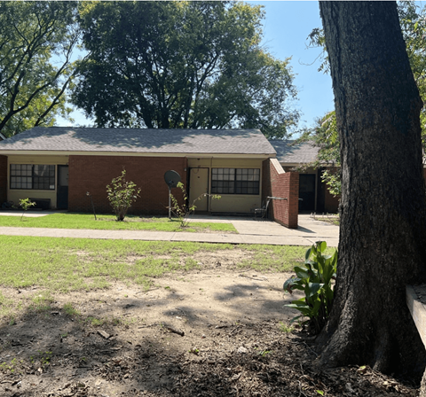 a house with a yard and a tree in front of it