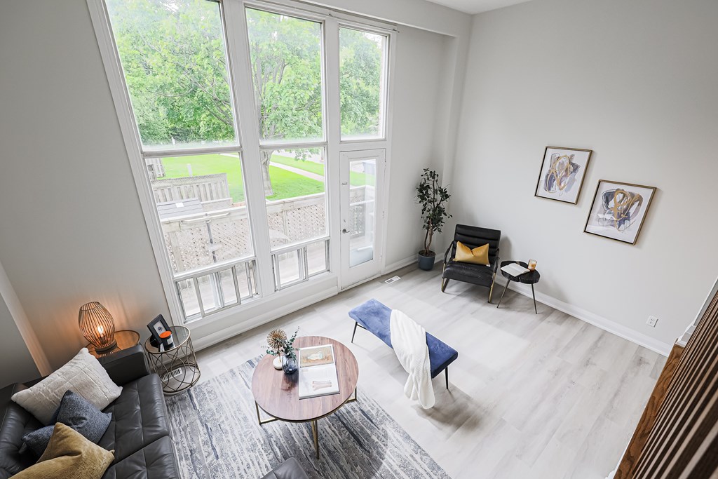 A living room with a black couch, a blue chair, and a coffee table.