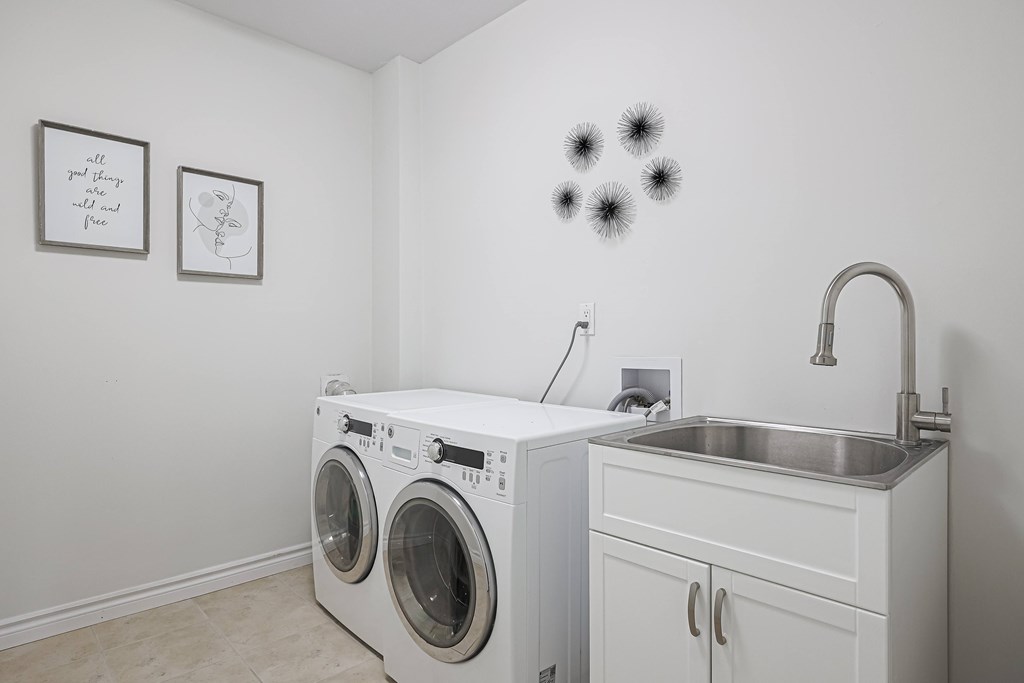 A white laundry room with a washer and dryer.