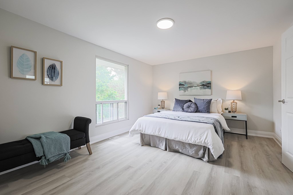 A bedroom with a large bed and a chair.