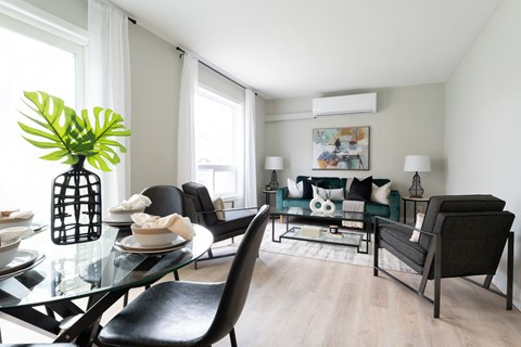 a living room with a glass table with chairs and a couch