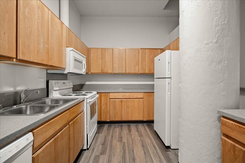 A kitchen with wooden cabinets and white appliances.