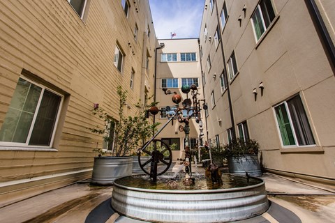 A fountain in the middle of a courtyard surrounded by buildings.