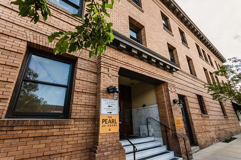 A brick building with a sign that says "The Pearl on Adams".