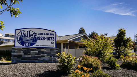 A sign for Valley Spa and Housing is displayed in front of a house.