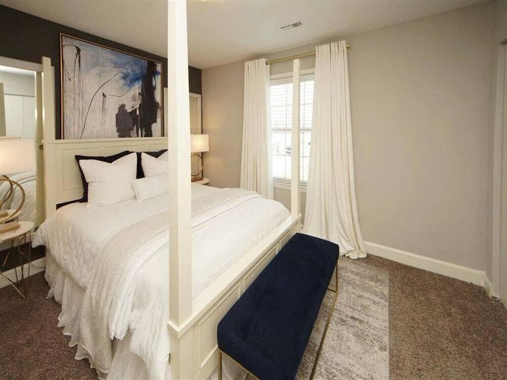 a white bedroom with a bed and a window