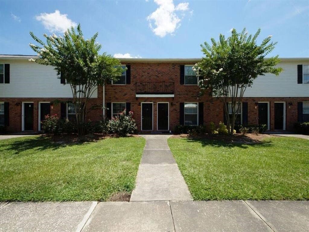 a brick building with a sidewalk in front of it
