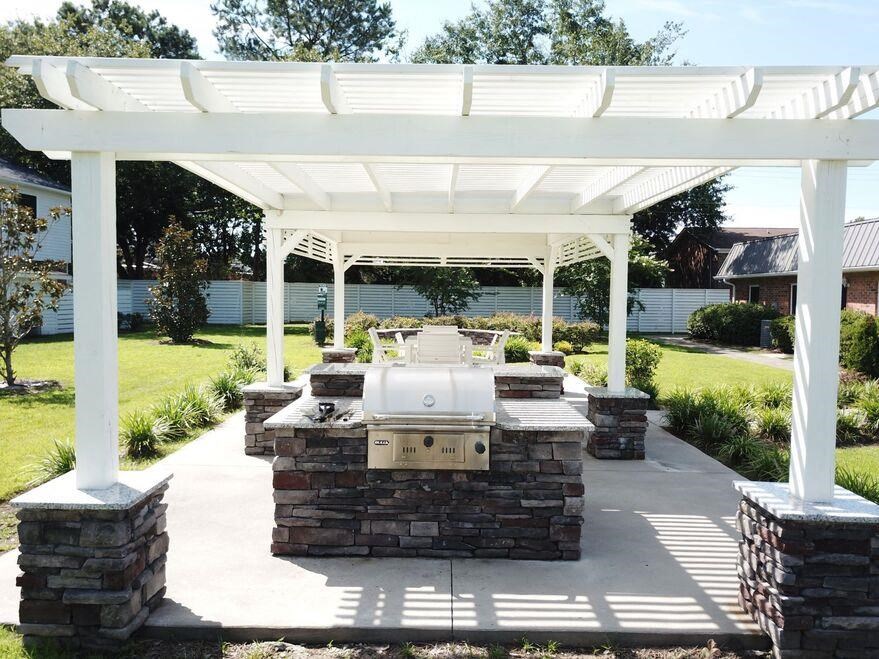 a patio with a grill and a white canopy