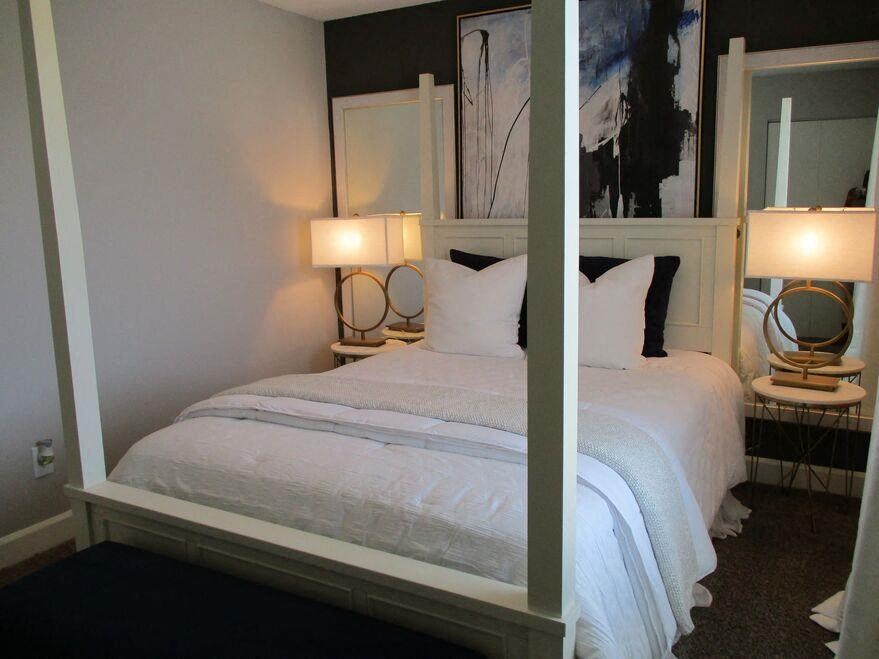 a bedroom with a bed and two lamps