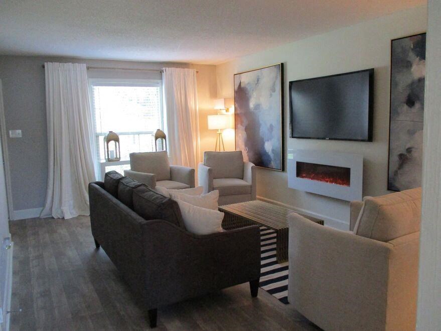 a living room with couches and chairs and a television