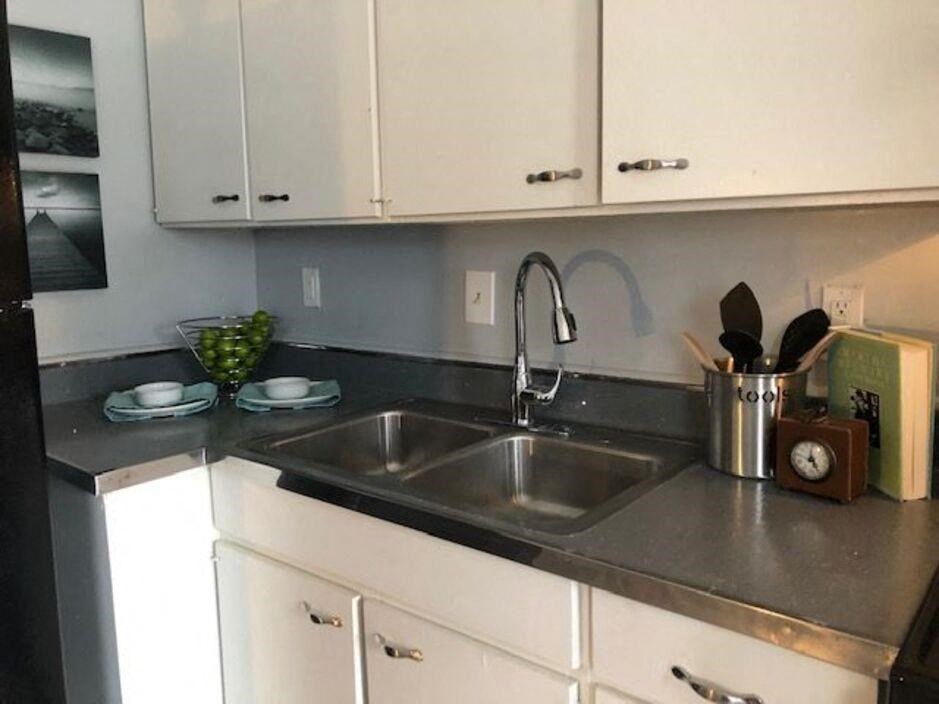 a kitchen with a stainless steel sink and white cabinets