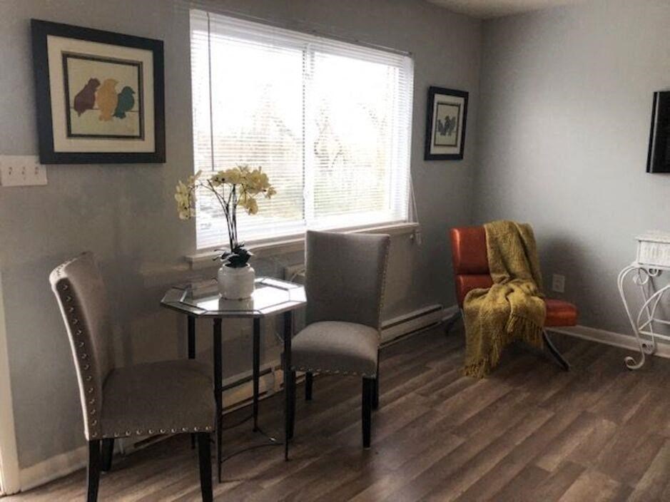 a living room with a table and chairs and a window