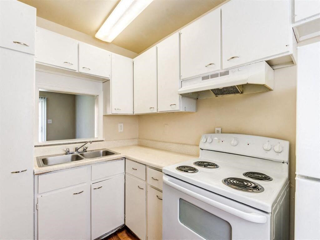 a white kitchen with white appliances and white cabinets