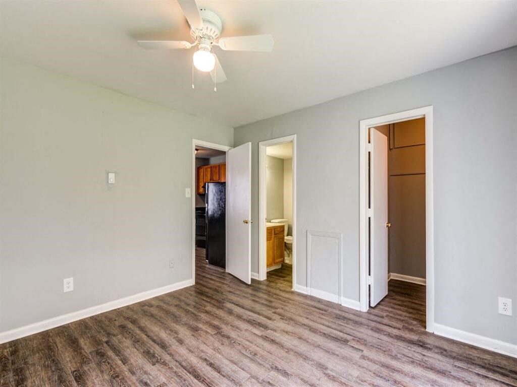 a living room with a ceiling fan and a door to a closet