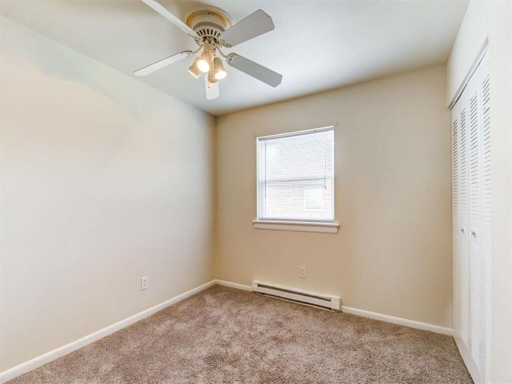 a bedroom with a ceiling fan and a window