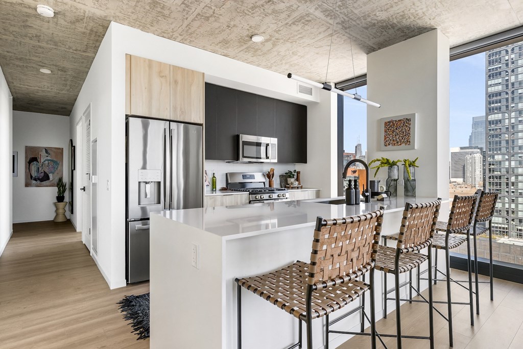 a kitchen with a large island and bar stools in a modern apartment