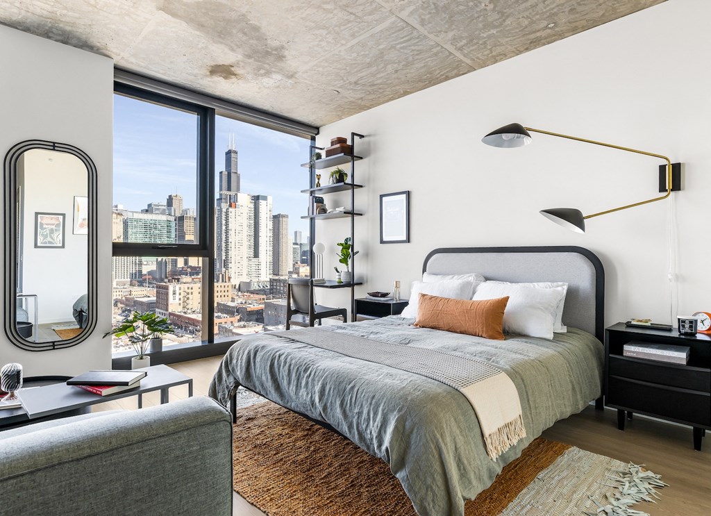 a bedroom with a bed and a large window