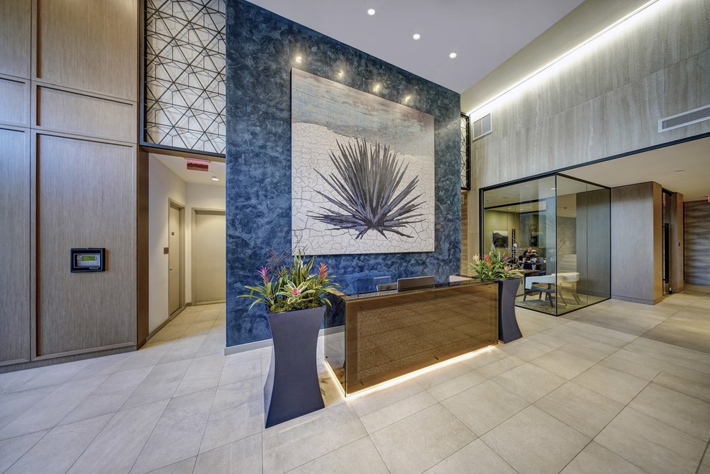 the lobby of a hotel with a blue wall and a reception desk