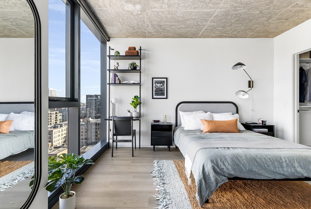 a bedroom with a bed and a large window