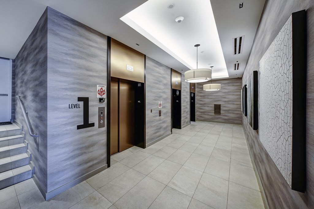 a hallway with elevators and marble walls and flooring
