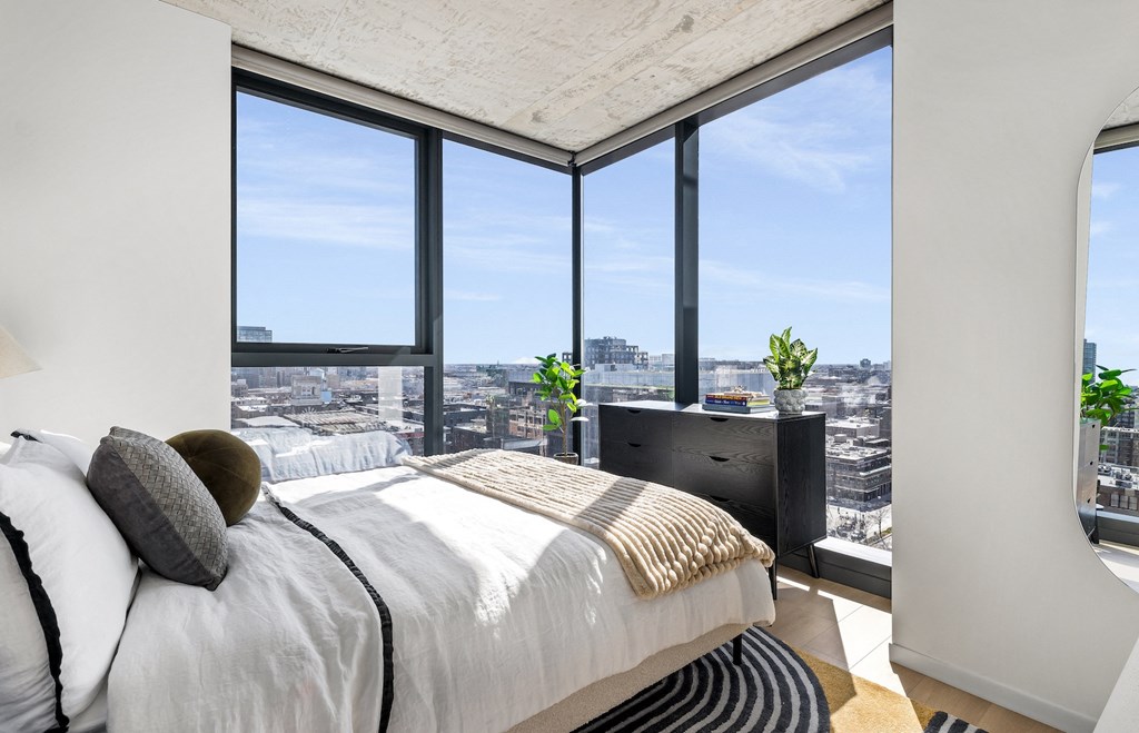 a bedroom with a bed and a view of the city
