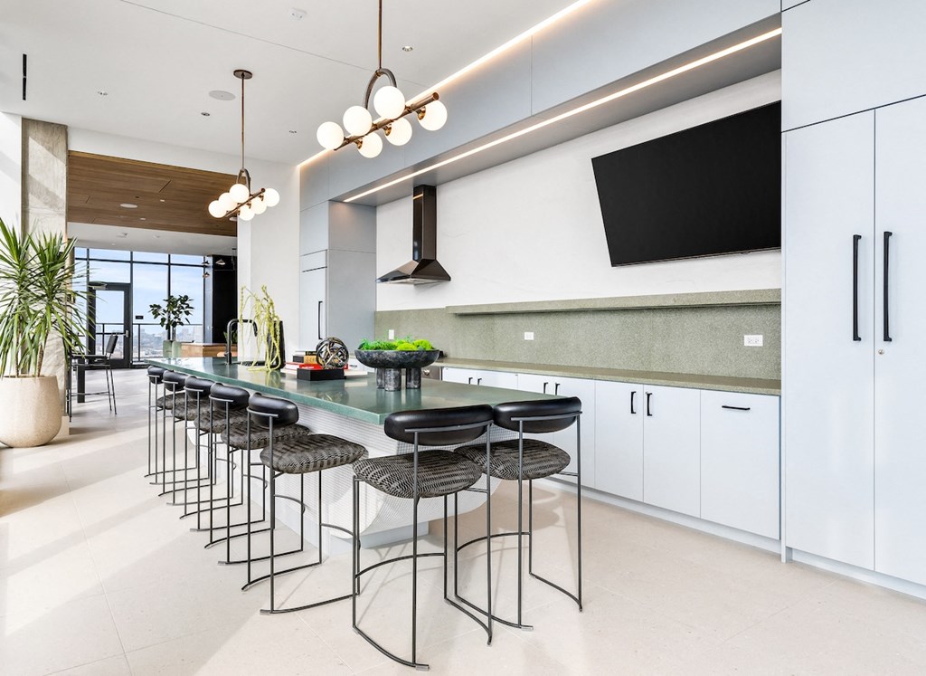 a kitchen with white cabinets and a long table with black chairs