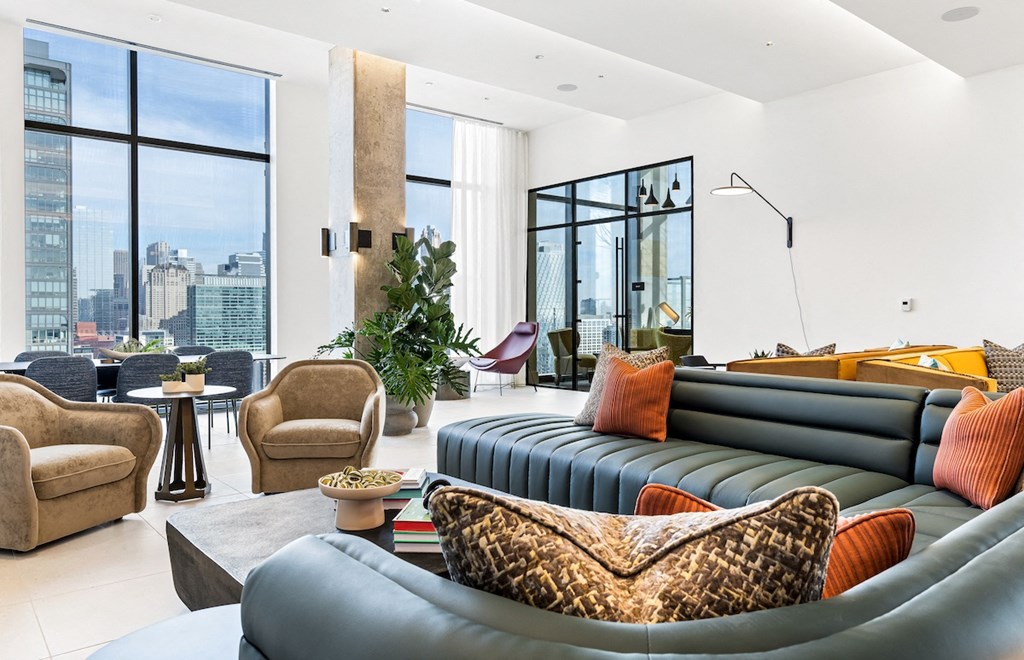 a living room with couches and chairs and a city view