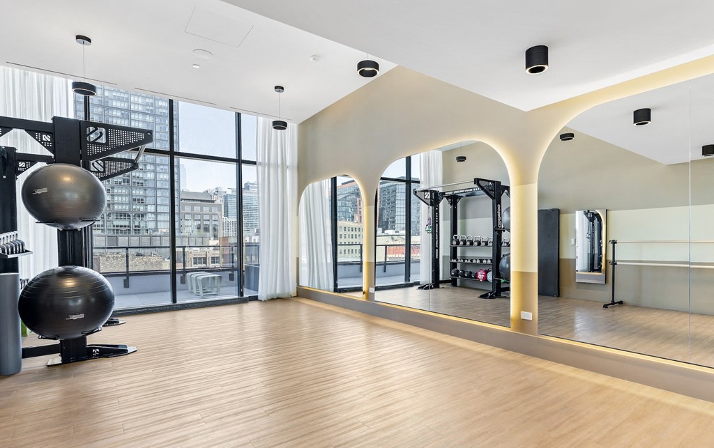 a gym with a yoga ball and other exercise equipment in a room with large windows