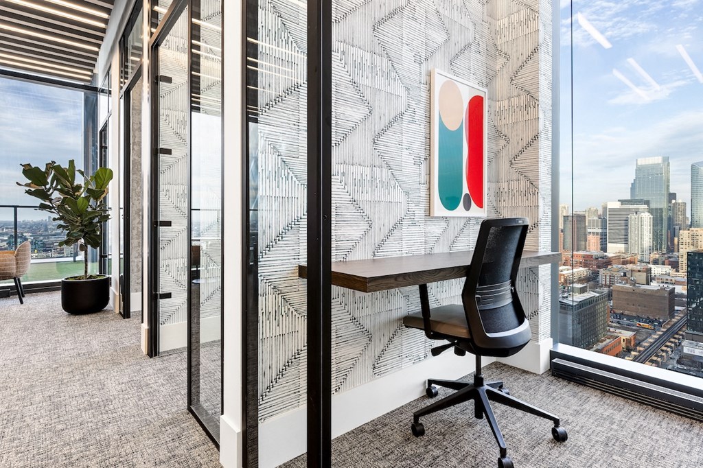 a desk in an office with a view of the city