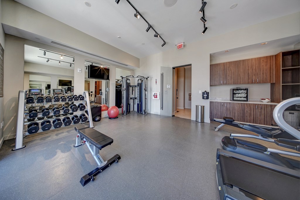 the gym with weights and cardio equipment at the belgard apartments