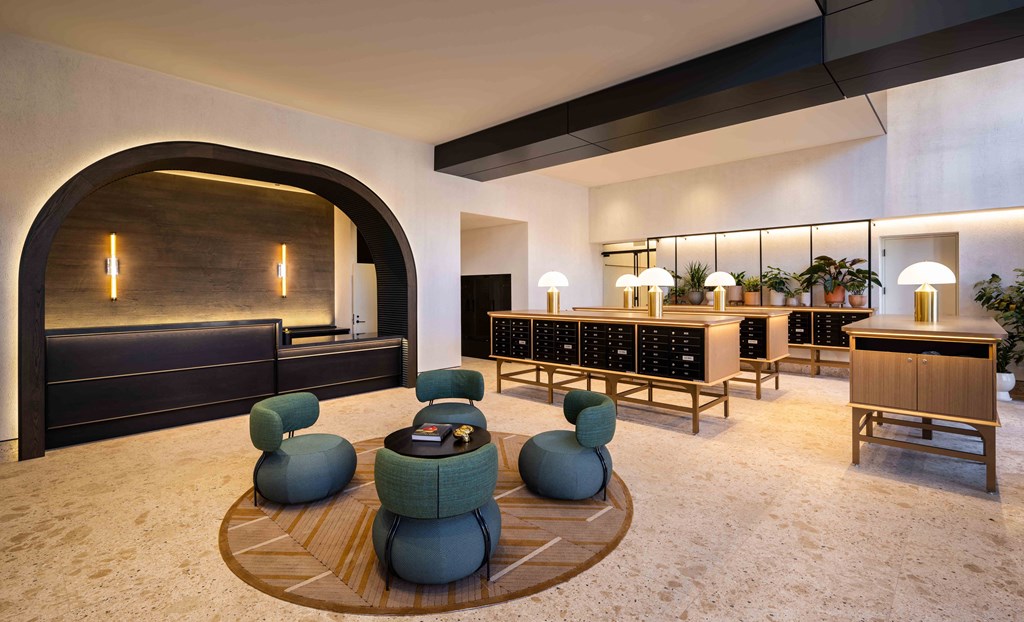 a lobby of a hotel with chairs and tables