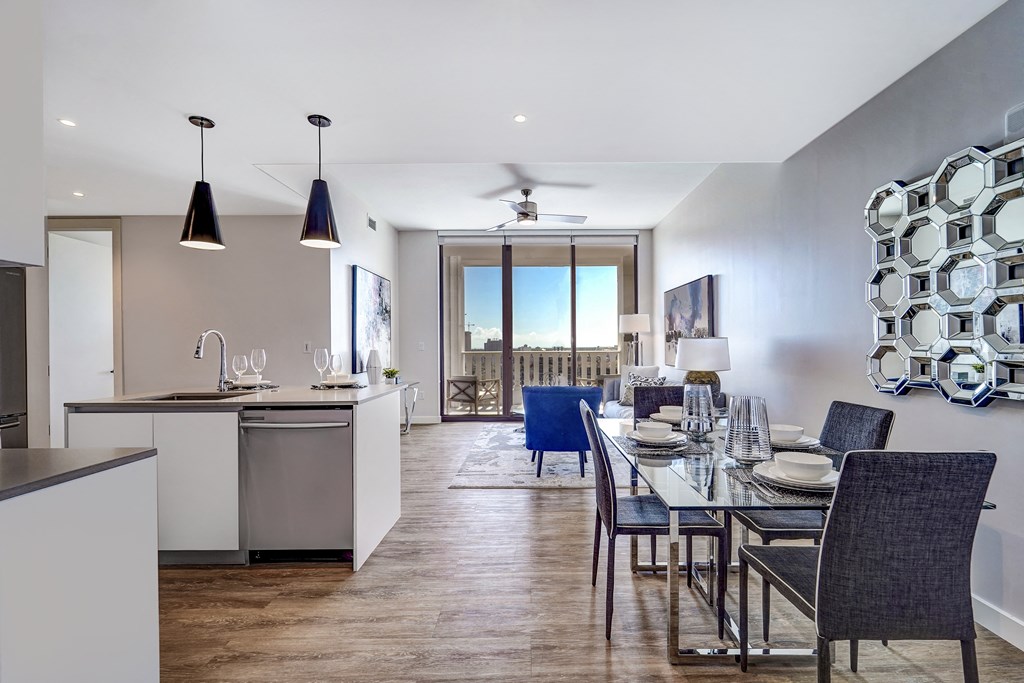 a dining room and kitchen area with a glass table and chairs