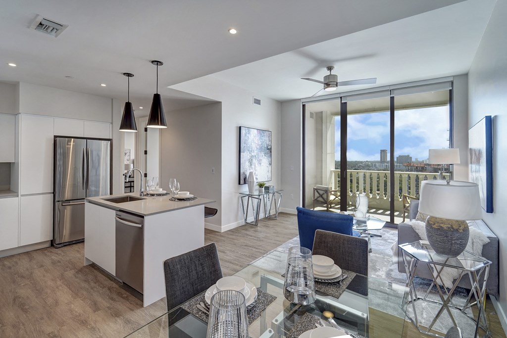 a living room and dining room with a table and chairs and a kitchen