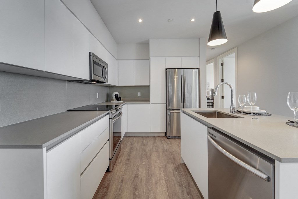 a kitchen with white cabinets and stainless steel appliances