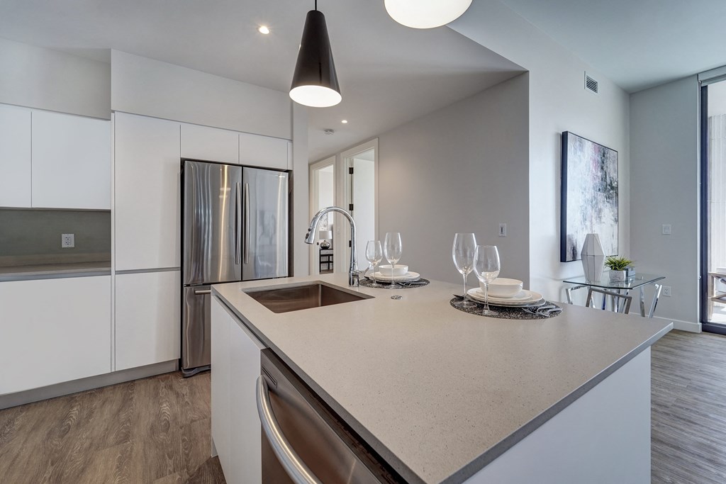 a kitchen with white cabinets and a large island with a sink and