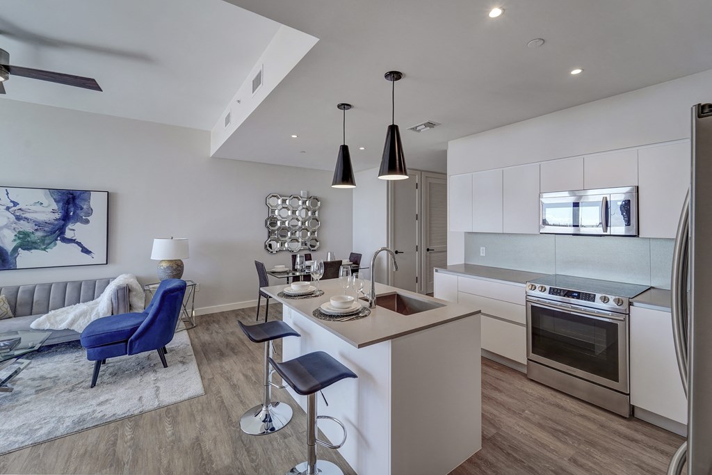 a kitchen and living room with an island and a table with chairs