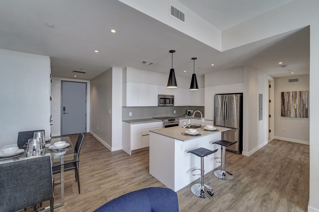 a kitchen and dining room with white cabinets and a table with chairs