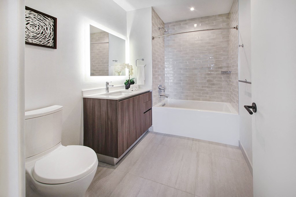 a bathroom with a toilet and a tub and a sink